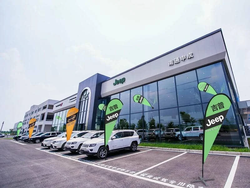 Jeep汽车品牌旗舰店户外广告系统-4S店绿色品牌标识应用(含玻璃幕墙吸盘mini旗+多车型水滴旗展示方案)