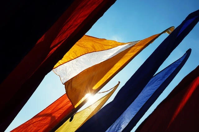 Colorful Bali banners waving in the wind under blue sky Vibrant yellow and white Bali banners waving under blue sky for festive outdoor advertising.