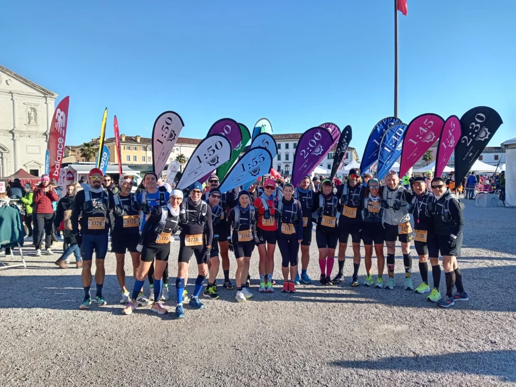 Squadra di pacemaker con zaini WZRODS per maratona e diverse bandierine di ritmo durante una maratona