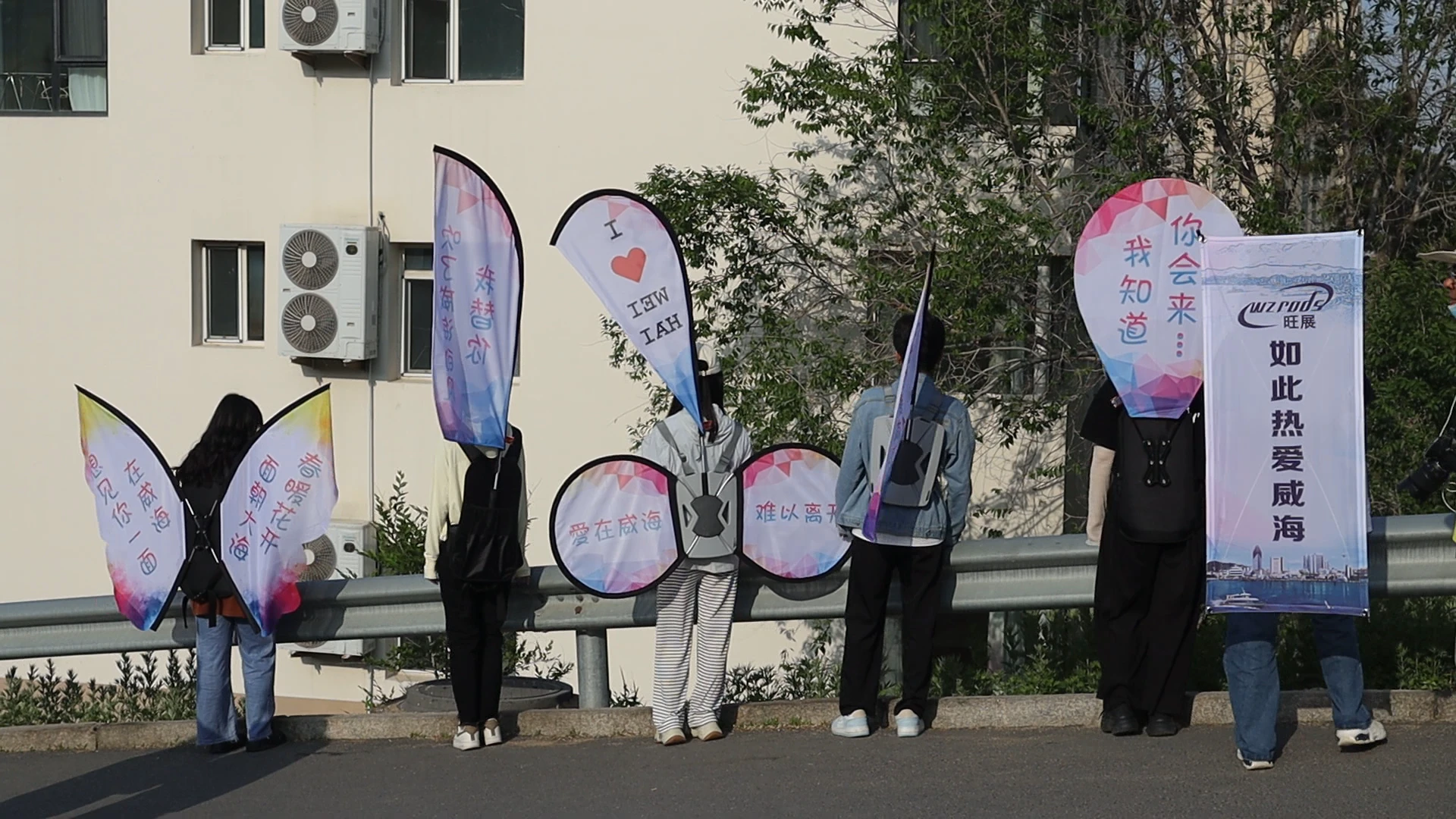 Team holding custom teardrop promotional flags for a city love campaign in Weihai, perfect for outdoor street marketing.