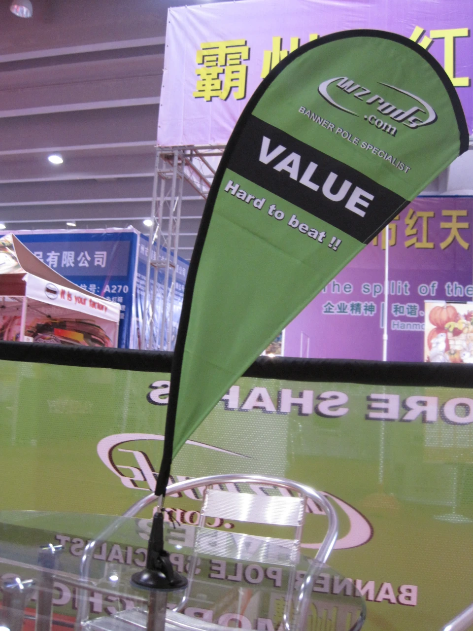 Car window flag with carbon fiber flagpole gallery 19 Green car window flag with 'VALUE' text, displayed at an exhibition.