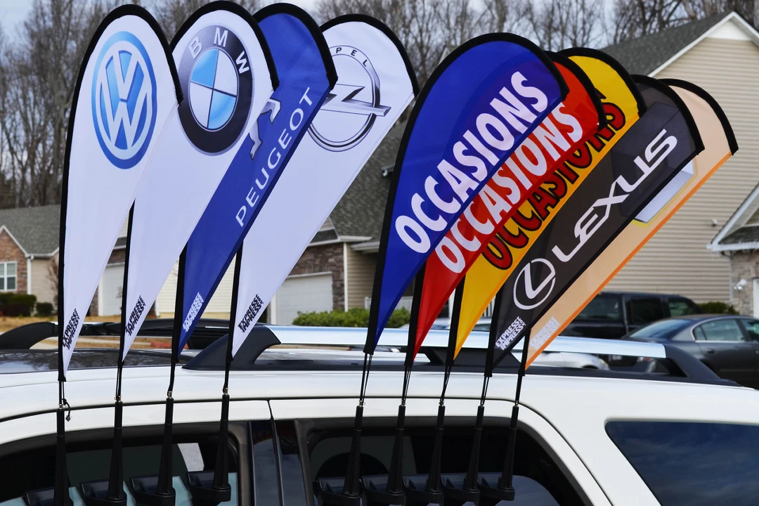 Volkswagen, BMW, Peugeot car window teardrop flags with 'OCCASIONS' text on white vehicle.