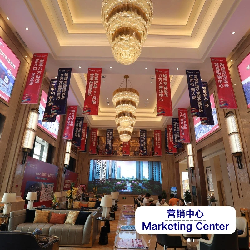 Luxury real estate marketing center with red banners, chandeliers, and high-rise building projection