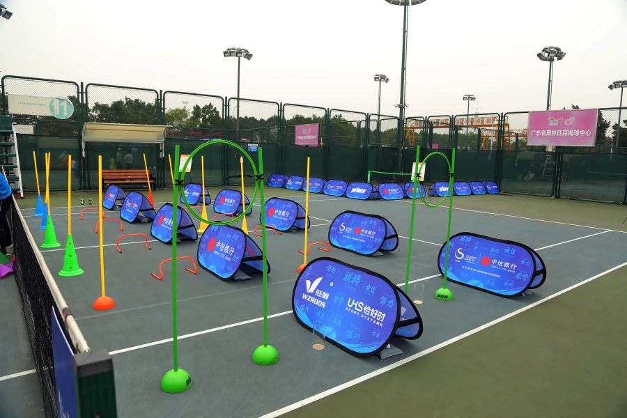 Pop up banners and agility equipment arranged on a tennis court for youth training activities