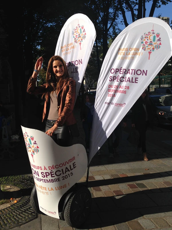 Promotional tear flags for a Paris Open moon festival event, with a brand ambassador on a Segway.