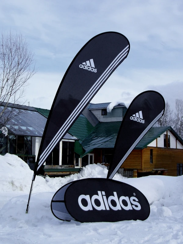 Adidas Wassertropfenflaggen im winterlichen Einsatz mit Standfuß auf Schnee